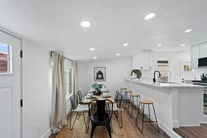 Dining space featuring dark hardwood / wood-style floors, lofted ceiling, and sink