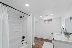 Full bathroom with toilet, hardwood / wood-style floors, vanity, and shower / tub combo with curtain