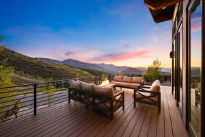 Deck at dusk with outdoor lounge area and a mountain view