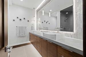 Bathroom featuring tile patterned floors, vanity, and a shower with shower door