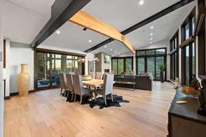 Dining area with lofted ceiling with beams, light wood-type flooring, and plenty of natural light