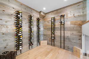 Wine room with hardwood / wood-style floors and wooden walls