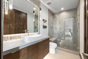 Bathroom with tile patterned flooring, vanity, toilet, and a shower with door