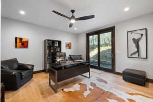 Living room with ceiling fan and light hardwood / wood-style flooring