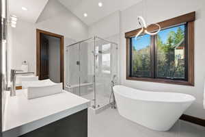 Bathroom with tile patterned floors, separate shower and tub, vanity, and lofted ceiling