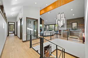 Hall with beam ceiling, light wood-type flooring, and high vaulted ceiling