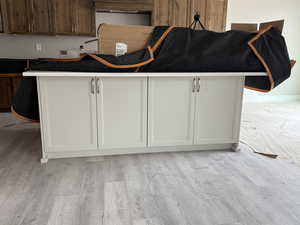 Kitchen with white cabinets and light wood-type flooring