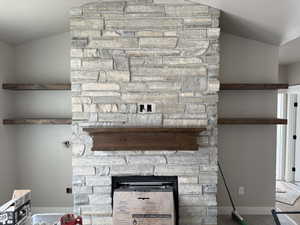 Room details with a stone fireplace and a textured ceiling