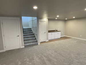 Basement featuring carpet flooring and sink