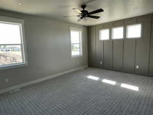 Unfurnished room with a textured ceiling, carpet floors, and ceiling fan