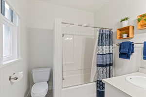 Full bathroom featuring shower / bath combo, vanity, and toilet