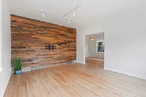 Front living room with reclaimed wood accent wall, and lots of natural light, with view into dining room