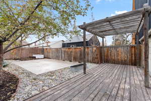 Amazing outdoor entertaining space! Wooden deck with a pergola, outdoor lounge area on the patio, surrounded with multiple raised garden beds