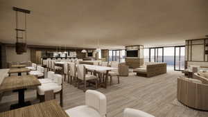 Dining room with a water view, a wall of windows, a textured ceiling, and light hardwood / wood-style flooring