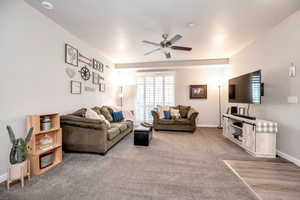 Living room featuring carpet flooring and ceiling fan