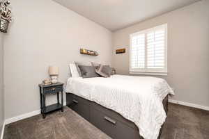 Bedroom with dark colored carpet