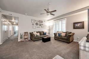 Living room with carpet and ceiling fan