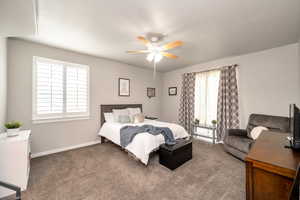 Bedroom with dark colored carpet and ceiling fan