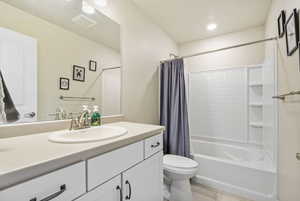 Full bathroom with tile patterned flooring, vanity, toilet, and shower / bathtub combination with curtain