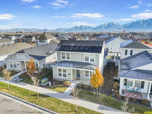 View of front of property with a mountain view and solar panels