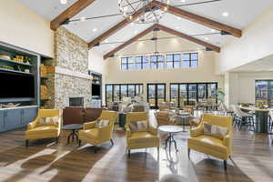 Living room featuring beamed ceiling, dark hardwood / wood-style floors, high vaulted ceiling, and a chandelier