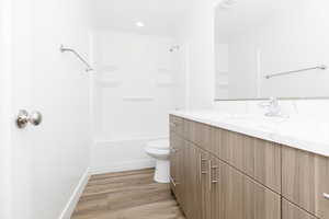 Full bathroom with vanity, hardwood / wood-style flooring, toilet, and tub / shower combination