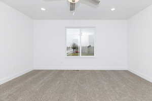 Spare room featuring carpet flooring and ceiling fan