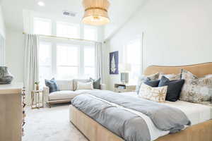 Primary Bedroom with light carpet and high vaulted ceiling