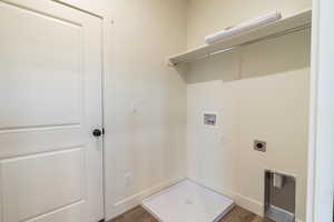 Clothes washing area featuring dark wood-type flooring, washer hookup, and hookup for an electric dryer