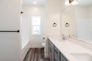 Bathroom featuring hardwood / wood-style floors, vanity, and toilet