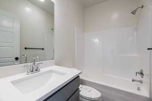 Full bathroom featuring toilet, vanity, and washtub / shower combination