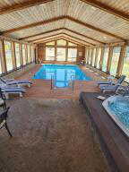 View of community indoor swimming pool featuring a hot tub