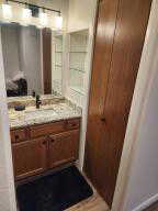 Bathroom featuring vanity, closet and glass shelving