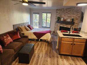 Great Room featuring sink, ceiling fan, access to exterior, light wood-type flooring, and a fireplace