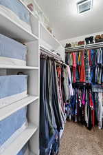 Walk in closet featuring Lots of well placed shelves and rods to hang your fancy dresses, outfits, purses, shoes and hats.