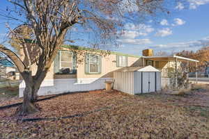 Rear view of house featuring a storage shed