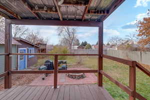 Deck with a patio area, an outdoor structure, and a yard