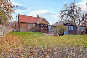 Rear view of house featuring a yard and a sunroom