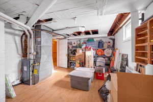 Basement with heating unit and hardwood / wood-style floors