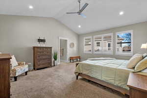 Bedroom featuring light carpet, vaulted ceiling, and ceiling fan