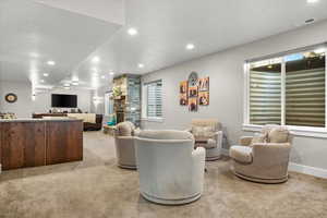 Carpeted living room with a textured ceiling and a stone fireplace