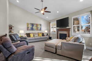 Living room featuring carpet floors, high vaulted ceiling, and ceiling fan