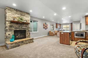 Carpeted living room with a stone fireplace and a textured ceiling