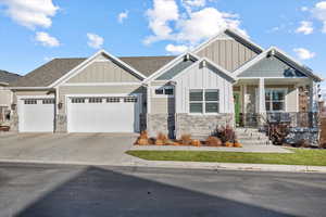 Craftsman-style home featuring covered porch and a garage