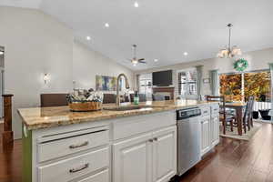 Kitchen featuring vaulted ceiling, sink, dishwasher, a center island, and dark hardwood / wood-style floors