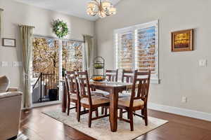 Dining area with wood-type flooring, a wealth of natural light, and a notable chandelier