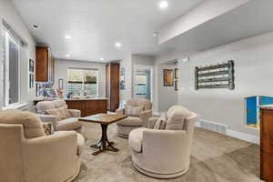 Living room with light colored carpet and a textured ceiling