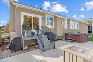 Back of house with a patio and a hot tub