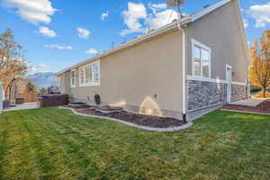 View of side of property with a mountain view and a yard