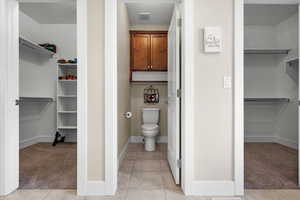 Bathroom featuring tile patterned flooring, a textured ceiling, and toilet